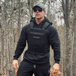 Man wearing black Centurion Weight Vest with hoodie in forest setting